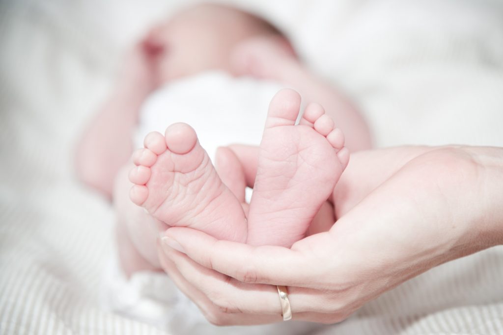 Newborn baby feet in mom's hand