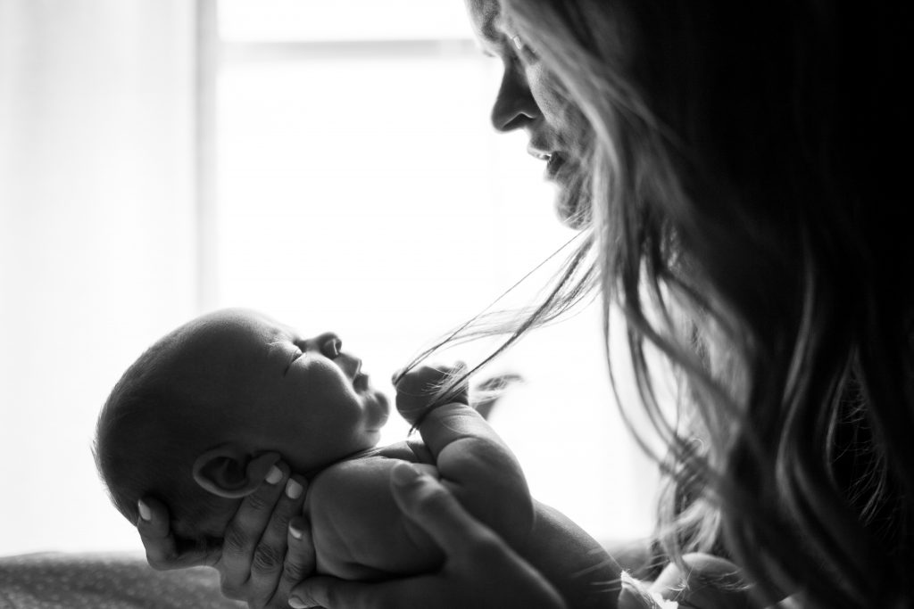 Mom holding newborn baby black and white