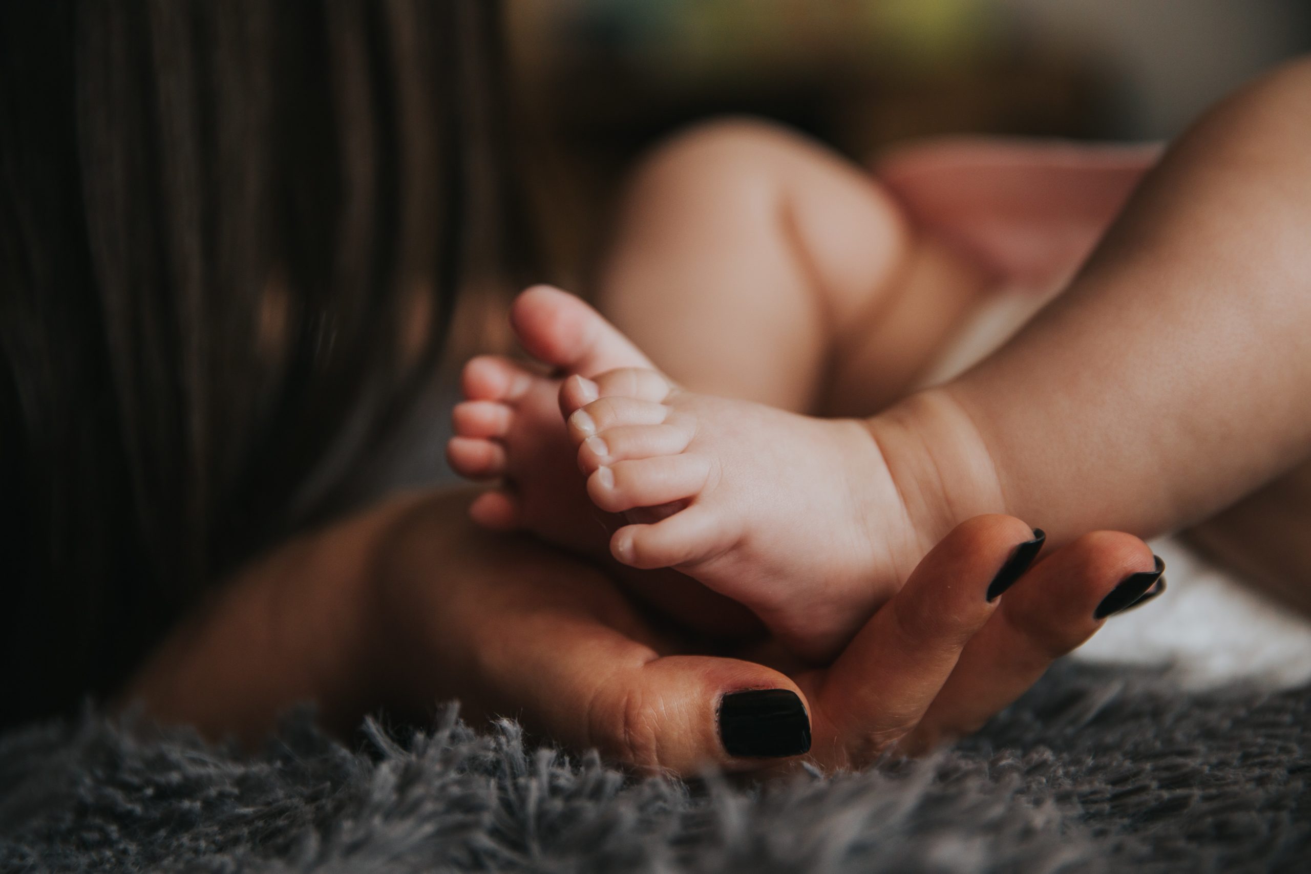 mom holding baby feet in close up